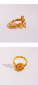 Detail of gold brass ring with irregular sunburst texture and clear zircon stone