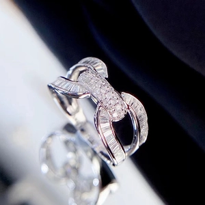 U-shaped interlocking silver ring with baguette and pavé zirconia on black surface