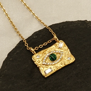 Detail of 18K gold rectangle pendant with malachite evil eye and white zircons