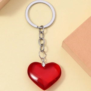3D translucent red resin heart keychain with silver metal ring on a neutral background