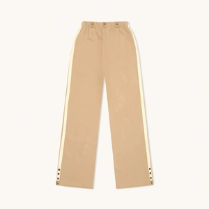 Pantalon large beige avec bandes blanches latérales et boutons pour un look sport rétro