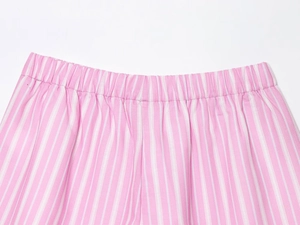 Detail of pink and white striped cotton fabric with elastic waistband and stitching