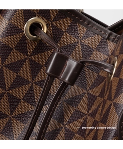 Close-up of geometric pattern bucket bag featuring gold eyelets and drawstring closure