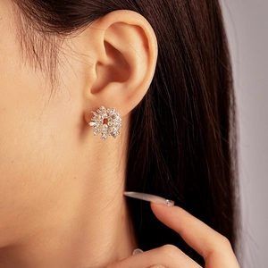 Primo piano di un elegante orecchino a lobo a fiore con zirconi e perle