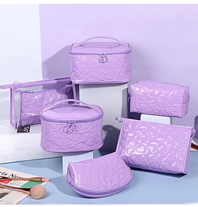 Macro view of purple heart-embossed makeup bags with reflective finish and PVC detail