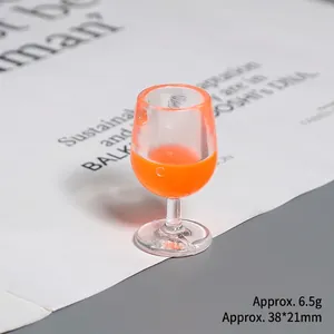 Close-up of a 38x21mm miniature red wine glass model with orange liquid and 6.5g weight