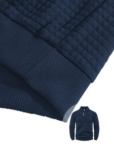 Close-up of dark blue men's sweater featuring quilted texture and buttoned polo collar