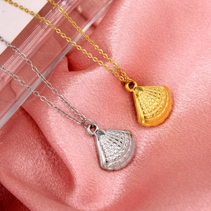 Vue macro de pendentifs en forme d'éventail or et argent sur des chaînes en soie rose