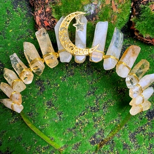 Detail of natural citrine raw stone crown with golden moon and star charms on mossy background