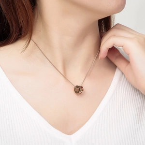 Rose gold necklace with three interlocking rings pendant worn by a model on neck