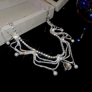 Macro shot of silver diamond-set necklace with fringe tassels and a pear-shaped drop pendant