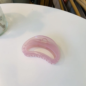 Detail of pink semi-circular hair claw clip showing translucent matte resin finish