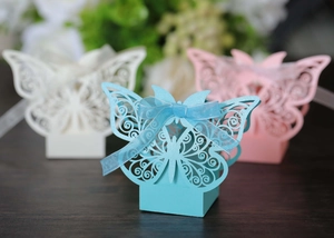 Detailed laser-cut butterfly candy boxes in sky blue, white, and pink with ribbon bows