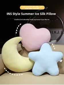 Détail des coussins en soie glacée en forme de cœur, lune et étoile sur canapé