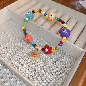 Macro detail of colorful beaded evil eye bracelet with Lucky gold pendant and gold spikes