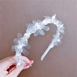 Close-up of white crystal flower headband with delicate pearl beads for elegant hair styling