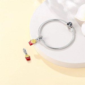 Close-up of S925 silver snake chain bracelet featuring a red and yellow fries charm