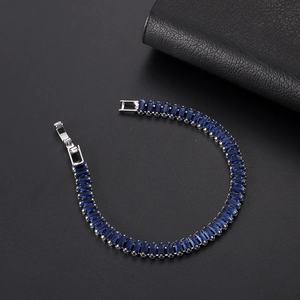 Detailed close-up of a luxury tennis bracelet featuring deep blue rectangular zircon stones