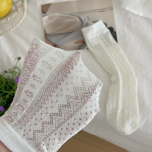 Detail of white lace hollow socks with intricate geometric patterns and breathable mesh