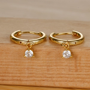 Detailed macro view of gold-plated hoop earrings featuring sparkling round cubic zirconia drops