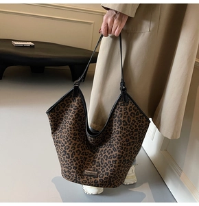 Detail of leopard print tote bag with black leather straps and large capacity for women