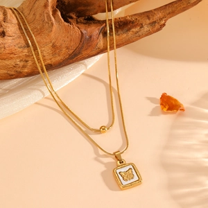 Detailed macro view of 18K gold-plated double-layer snake chain with butterfly pendant
