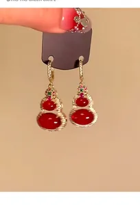 Detail shot of 14k gold plated gourd earrings with red agate and sparkling zirconia accents