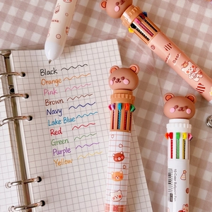 Cute 10-in-1 retractable multicolor ballpoint pen with 3D bear topper on a notebook