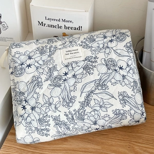 Quilted floral makeup bag with ink wash patterns and soft fabric texture on wood