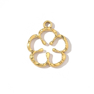 Close-up of golden clover flower pendant accessory with hammered texture on white background