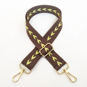 Detail of adjustable woven shoulder strap with yellow chevron pattern and gold hardware