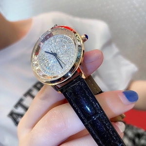 Close-up of luxury gold watch dial with sparkling crystals and premium black leather strap