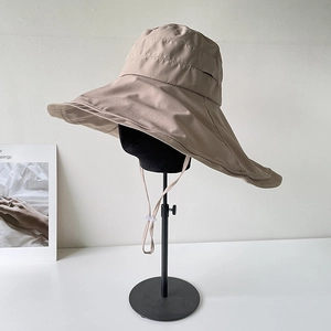 Detail of khaki wide-brim sun hat with adjustable windproof strap and quick-dry fabric
