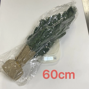 Macro view of a 60cm green mini Christmas tree on a scale with burlap base detail