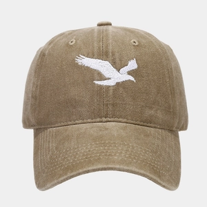 Gros plan sur la broderie d'aigle blanc sur une casquette vintage en coton délavé