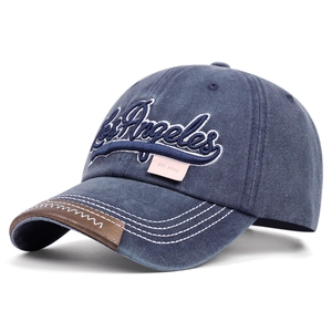 Detail of blue washed denim baseball cap with Los Angeles embroidery and leather trim