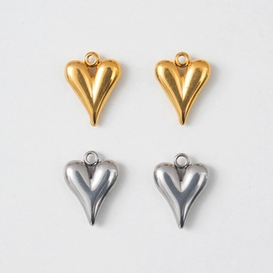 Flat lay view of heart-shaped stainless steel jewelry charms in gold and silver finish