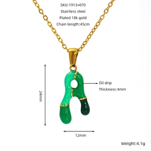 Detail of 18K gold plated stainless steel letter A pendant with green enamel finish