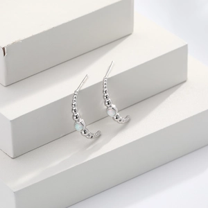 Detailed view of silver S925 geometric C-shaped earrings with white opal stone inlay