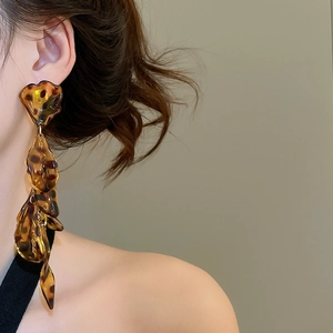 Close-up of model wearing acrylic leopard print petal tassel earrings in retro style
