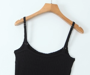 Détail de la robe noire en maille avec fines boucles métalliques réglables et tissu texturé