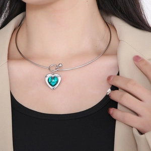 Detailed view of an elegant silver stainless steel choker with a green heart crystal pendant