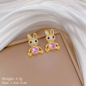 Detailed view of gold rabbit earrings with pink heart stones and zircon inlay