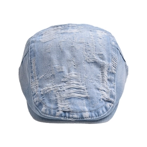 Detailed view of light blue denim beret featuring vintage distressed fraying and ripped holes