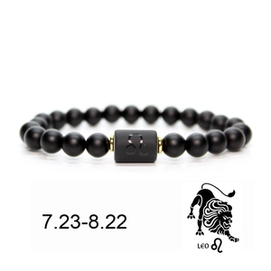Detail of matte black Leo zodiac bead bracelet with golden metal spacers and symbol