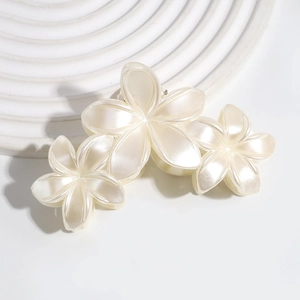 Detail of pearlescent lily flower hair claw clip with elegant triple blossom design
