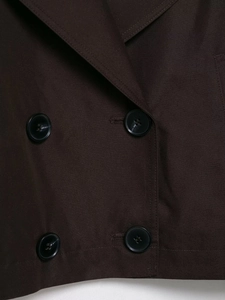 Detailed macro view of deep brown twill fabric with double-breasted button layout