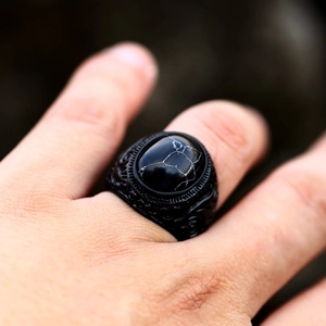 Dettaglio anello vintage da uomo in acciaio nero con gemma effetto marmo