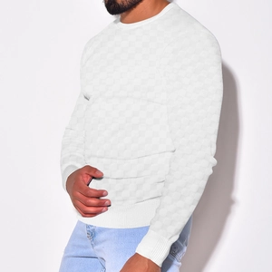 Close-up of white waffle knit texture and ribbed cuffs on men's crewneck sweater