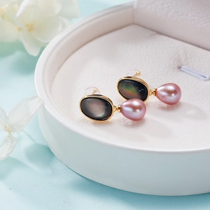 Elegant gold drop earrings featuring pink freshwater pearls and black shell in a white gift box